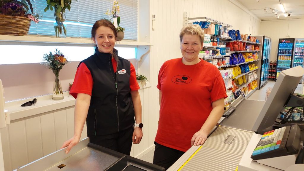 Elisabeth Sillibakken og Birgit Andresen smiler bak kassen i butikken.